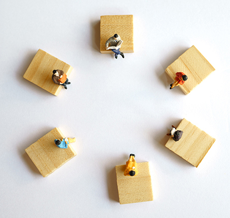 Model figures on wood planks visualizing the concept of social distancing..
